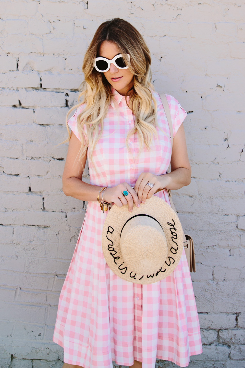 Dash of Darling styles an Eliza J gingham pink checkered poplin dress from Nordstrom with an Eugenia Kim straw boater hat and white Celine sunglasses for the perfect summer outfit.