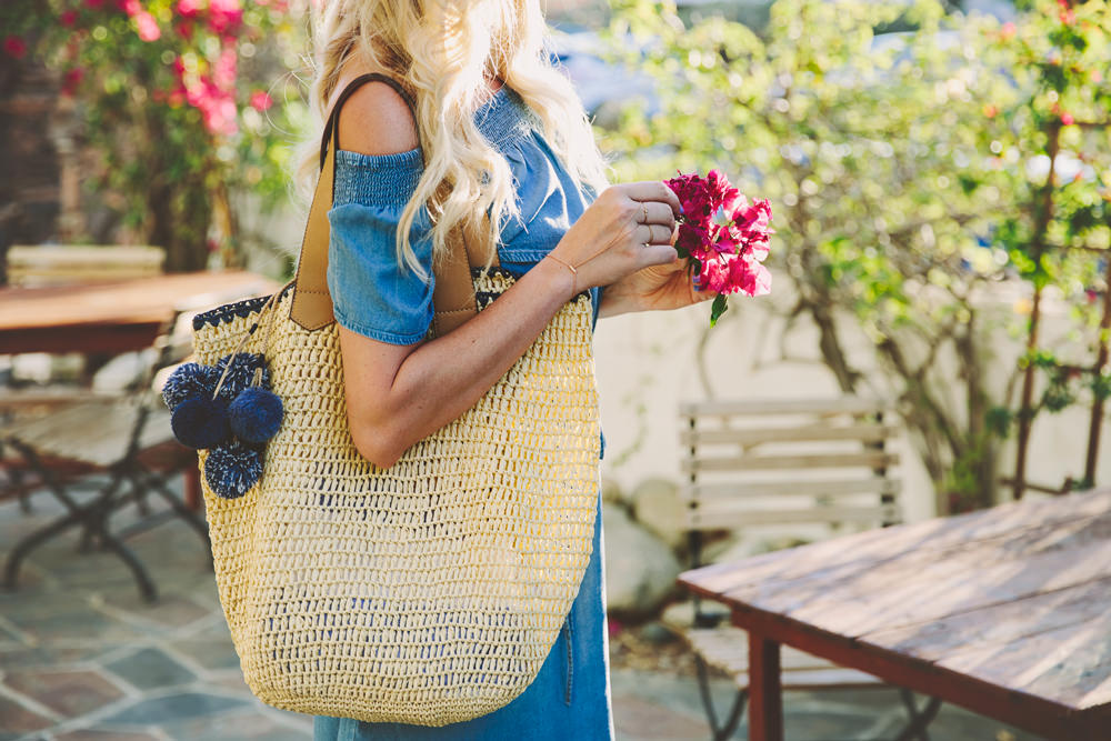 Dash of Darling styles a chambray off shoulder dress from LOFT with a pom pom straw tote for summer.