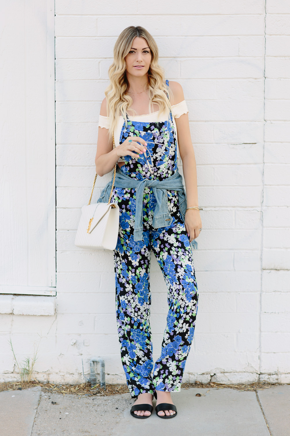 Dash of Darling styles a Wildfox blue bouquet overalls floral jumpsuit for summer with a denim jacket, ysl bag and an off the shoulder top.