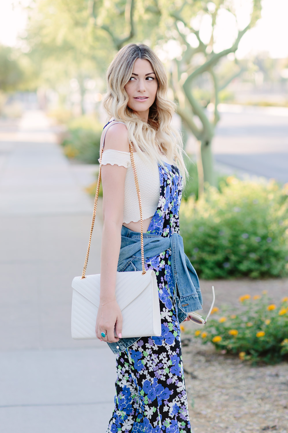 Dash of Darling styles a Wildfox blue bouquet overalls floral jumpsuit for summer with a denim jacket, ysl bag and an off the shoulder top.