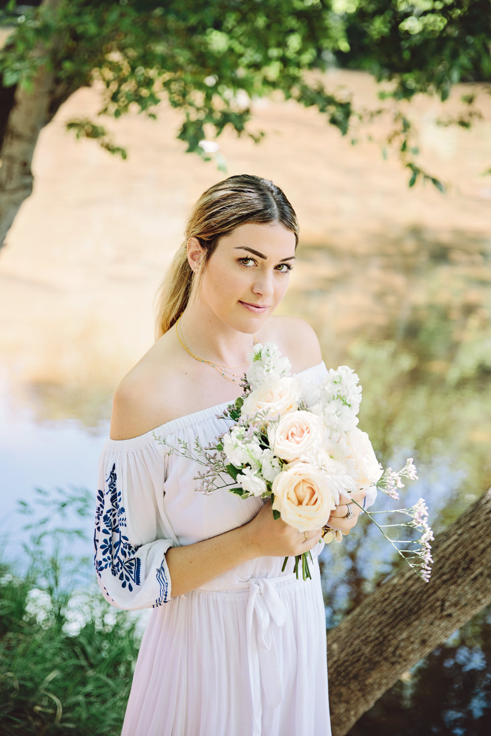 Dash of Darling wears a Tularosa off-shoulder white embroidered midi dress while on vacation in Sedona, Arizona and reviewing Philosophy shower gel for QVC.