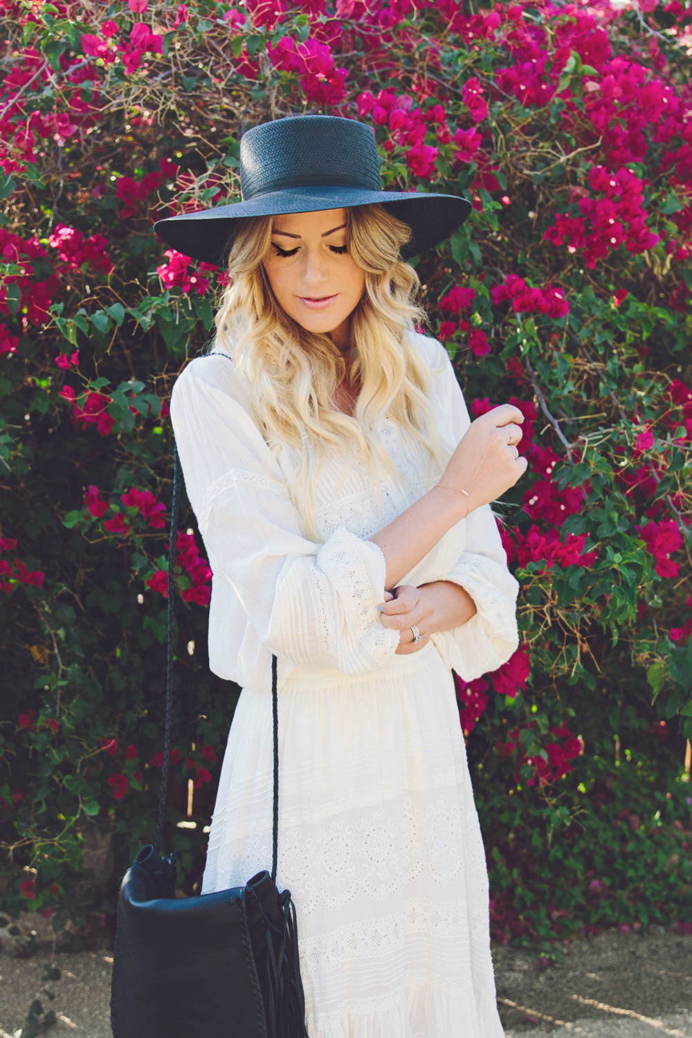 Dash of Darling wears a white Spell & The Gypsy Collective Byron Bay top and skirt with a Janessa Leone straw boater hat and a Jennifer Haley fringe bag while in Palm Springs staying at the Korakia Pensione hotel.