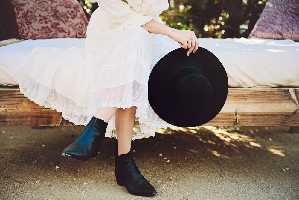 Dash of Darling wears the Acne Jensen boots with a Janessa Leone black straw boater hat with an all white Spell & the Gypsy Collective desert bohemian outfit.