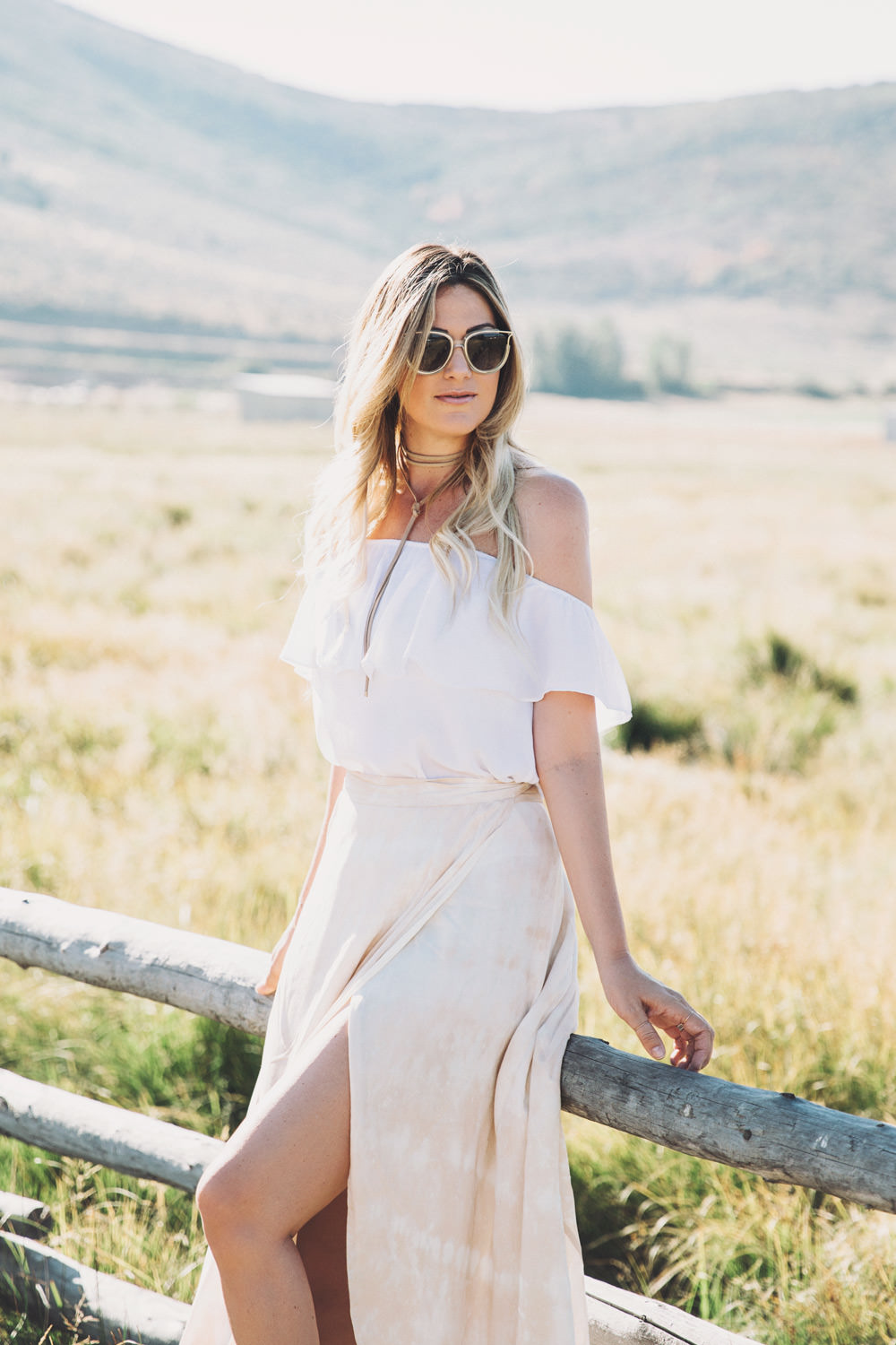 Caitlin Lindquist of the fashion blog Dash of Darling styles a Show Me Your Mumu off shoulder top with a wrap maxi skirt and Chloe sunglasses