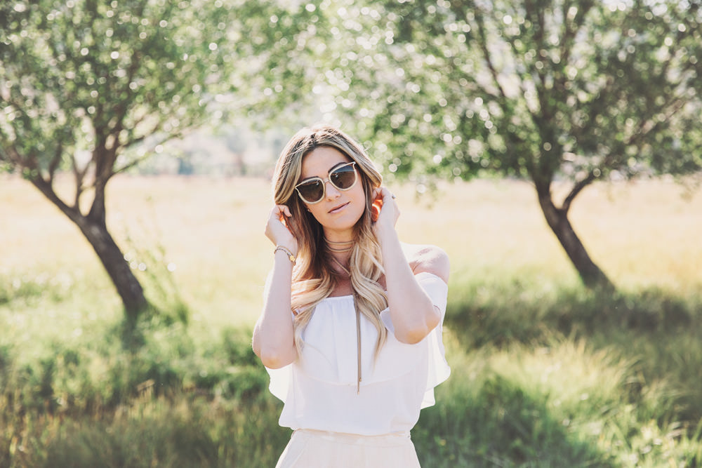 Caitlin Lindquist of the fashion blog Dash of Darling styles a Show Me Your Mumu off shoulder top with a wrap maxi skirt and Chloe sunglasses