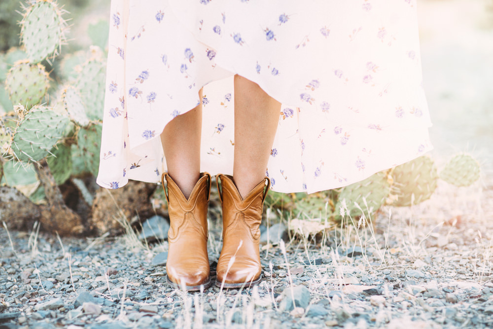 Caitlin Lindquist of Dash of Darling styles a romantic feminine Christy Dawn dress with Tecovas cowgirl boots in the desert.