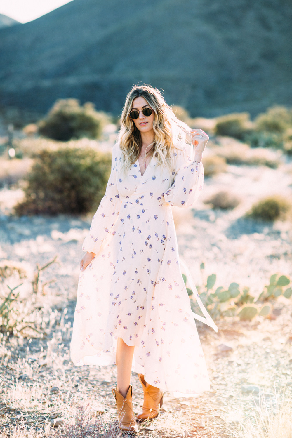 Caitlin Lindquist of Dash of Darling styles a romantic feminine Christy Dawn dress with Tecovas cowgirl boots in the desert.