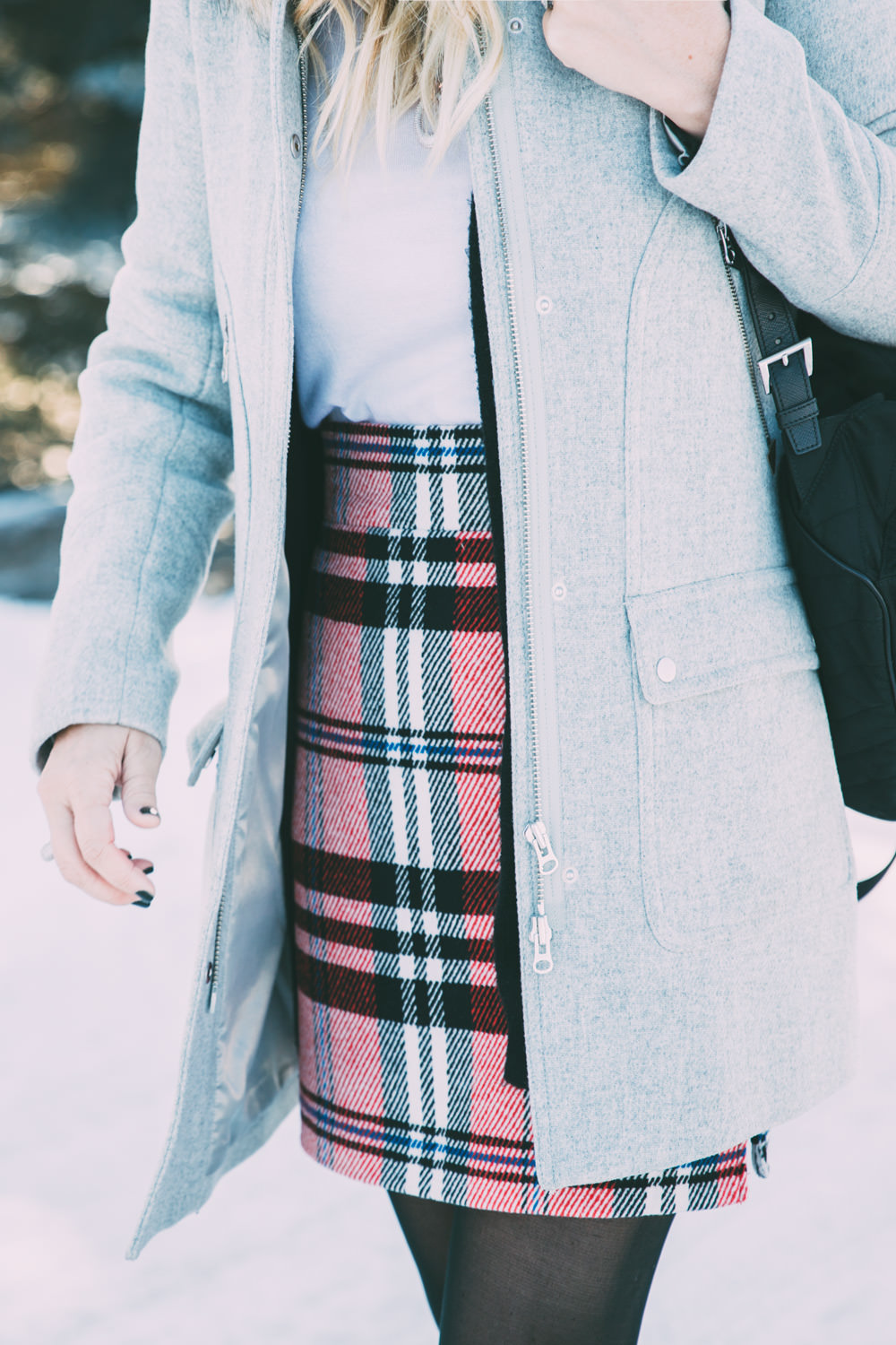 Caitlin Lindquist of the travel blog Dash of Darling shares a holiday winter outfit with Bronzallure in a Topshop plaid skirt, Club Monaco sweater and J.Crew fur hood coat.