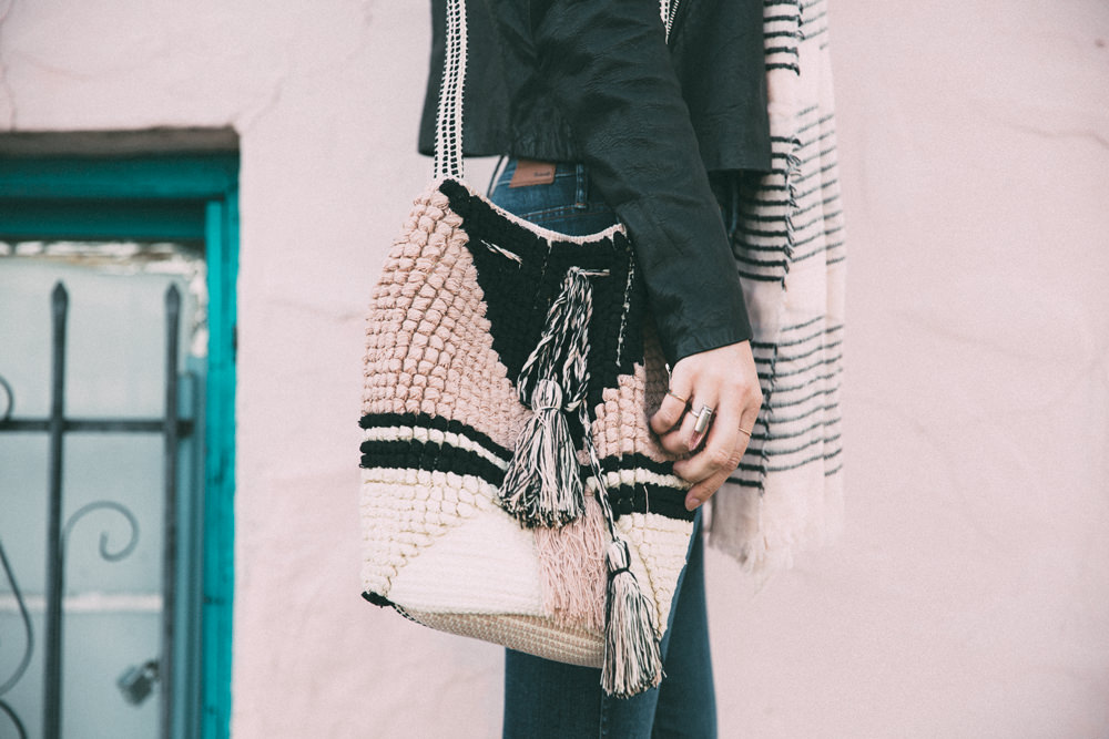 Dash of Darling shares a spring outfit wearing ripped denim with a bodysuit and pink stripe scarf and knit bag.
