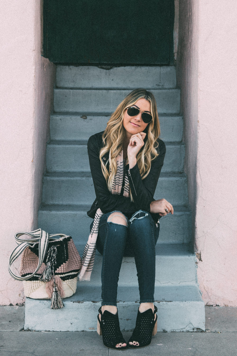 Dash of Darling shares a spring outfit wearing ripped denim with a bodysuit and pink stripe scarf and knit bag.