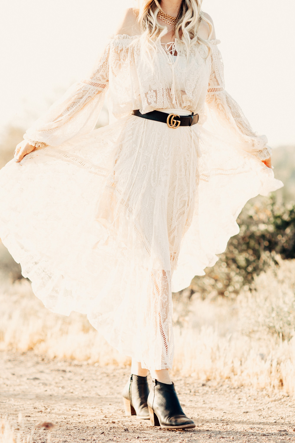 Caitlin Lindquist of the Arizona fashion blog Dash of Darling wears a Spell Designs white lace off shoulder top and skirt in the desert
