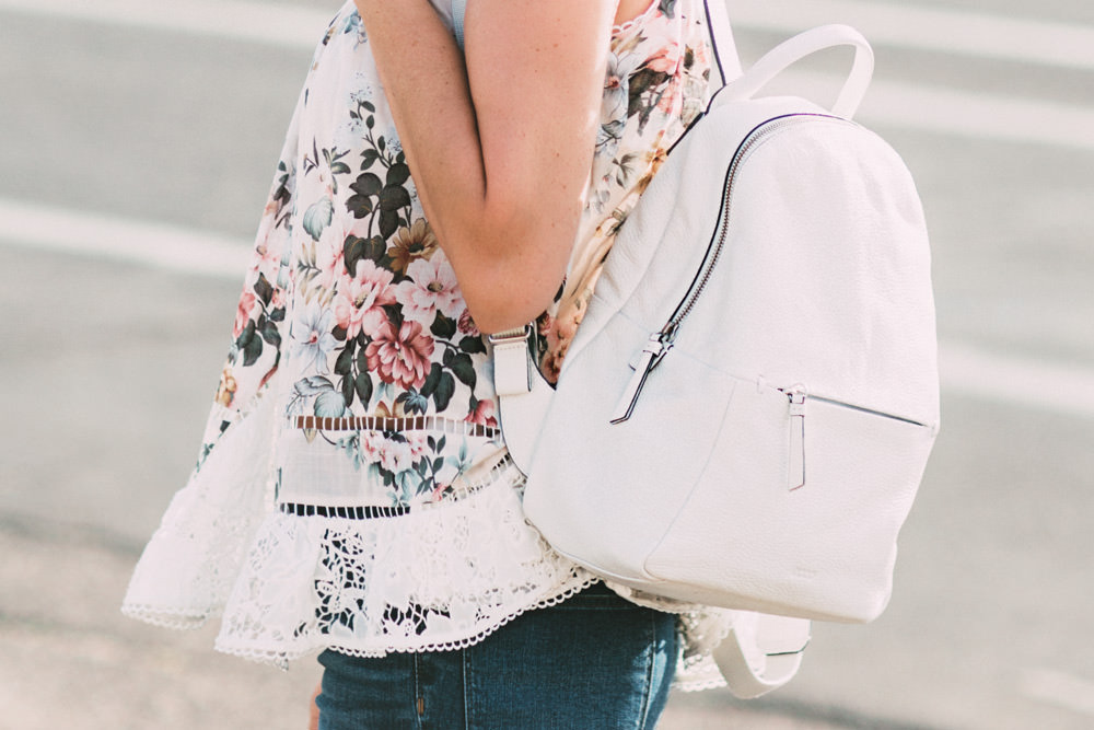 Caitlin Lindquist of the Arizona fashion blog Dash of Darling shares a casual outfit wearing a floral top and white backpack.