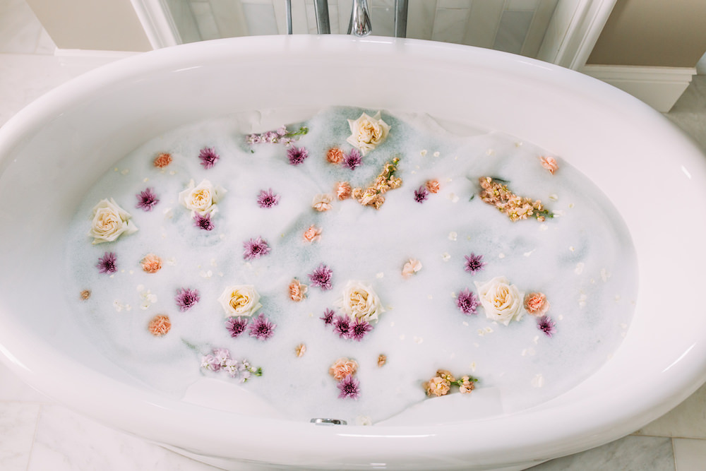 Caitlin Lindquist of the Arizona beauty blog Dash of Darling shares three steps to smooth summer skin while taking a relaxing bath with petals.