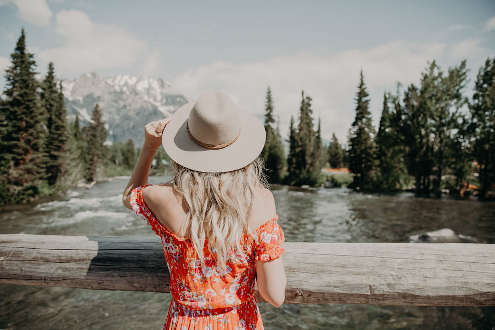 Dash of Darling shares an off shoulder orange dress in Jackson Hole, Wyoming while 21 weeks pregnant.